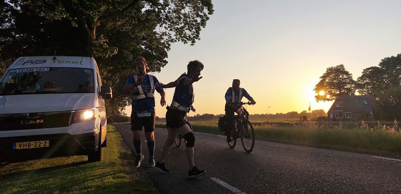 Loper en fietser bij zonsondergang tijdens de Roparun